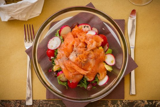 Smoked salmon salad with avocado, radishes, mixed leaves and olives in the photo by Cosimo Cortese