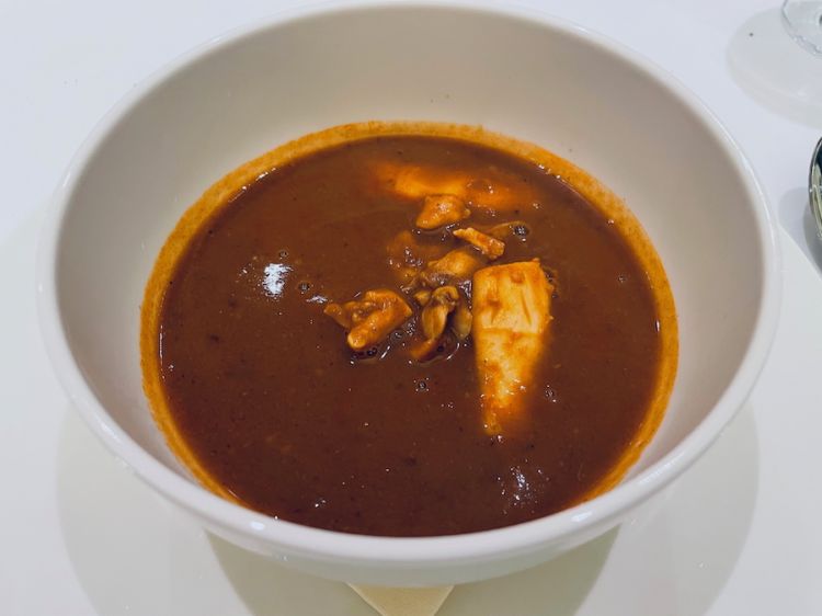Zuppa di crostacei e frutti di mare con gambero rosso di Mazara riserva di Paolo Giacalone, aragosta calamari cotti a bassa temperatura e vongole serviti in una bisque fibra di dattero per sgrassare
