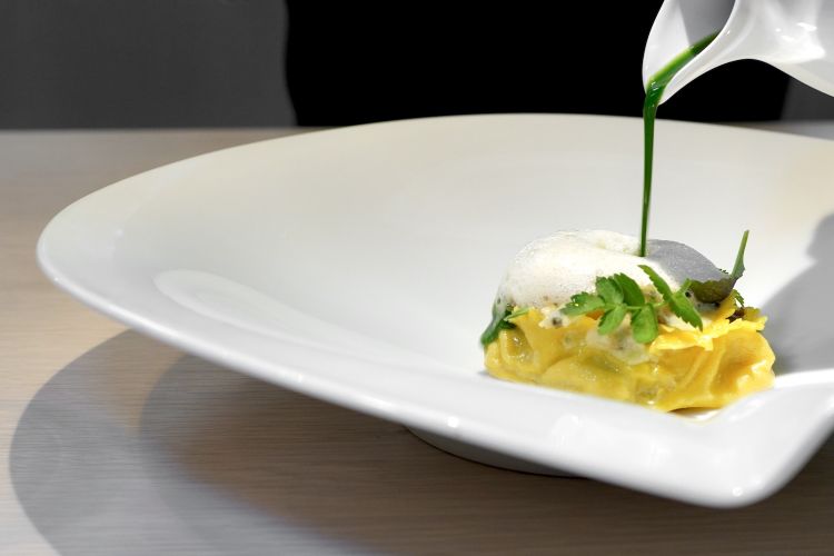 “Cartellata” filled with ray, black pepper, truffle, spinach and telline. The Christmas Apulian cake becomes a raviolo of fresh egg pasta filled with ray, plus a sauce with telline from Viareggio, air of rake liver, emulsion of black pepper, cream of herbs and Sancho pepper, spinach extract
