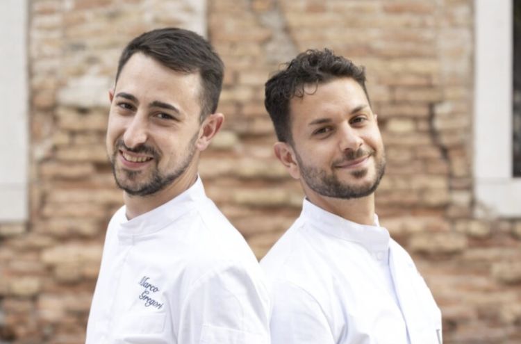 Marco Gregori e Nicol&ograve; Pometti. Il primo,&nbsp;vicentino, &egrave; un classe 1997&nbsp;nato a Torri di Quartesolo; ha studiato all&rsquo;alberghiero di Recoaro e mosso i primi passi tra cucine del territorio, passando anche da Corrado Fasolato e poi da Il Ridotto a Venezia. La svolta &egrave; arrivata con l&rsquo;esperienza in Spagna da Aponiente, il tre stelle Michelin di &Aacute;ngel Le&oacute;n, dove ha incontra Pometti. Rientrato in Italia, ha lavorato a lungo a La Peca di Lonigo, prima di ritrovarsi con Pometti&nbsp;alla guida di Wist&egrave;ria all&rsquo;inizio del 2025. Quest'ultimo,&nbsp;&egrave; invece un classe 1996, originario di Pontremoli, in Lunigiana. &Egrave; cresciuto in una famiglia di ristoratori ma inizialmente ha scelto un percorso diverso, frequentando il liceo linguistico e lavorando nell&rsquo;azienda di famiglia, attiva nella distribuzione di prodotti tipici lunigianesi. Poi ha cambiato strada, si &egrave; iscritto ad Alma, fatto uno stage a La Peca, &egrave; passato da Niko Romito e approda anche lui da Aponiente in Andalusia. Anche per lui il ritorno in patria &egrave; stato a&nbsp;La Peca, prima dell&rsquo;approdo veneziano
