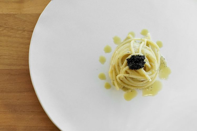 Spaghetto Martini e caviale: pasta al burro d'alghe, emulsione di olive verdi e vermouth, caviale italiano, gin taggiasco
