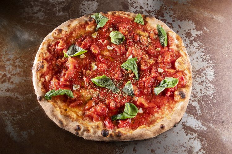 Marinara ai quattro pomodori. È la pizza iconica di Marasco, con pomodoro San Marzano dell'Agro Sernese-Nocerino Dop, antico pomodoro napoletano, pomodorino del Piennolo del Vesuvio, pomodoro ciliegino, aglio rosso di Nubia
