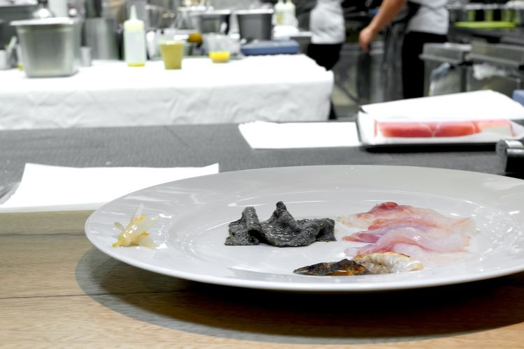 Branzino crudo, la sua pelle grigliata, fiori di limone sott'aceto e alga nori (che viene coperta di riso stracotto, seccata, fritta e poi messa a bagno in carpione)
