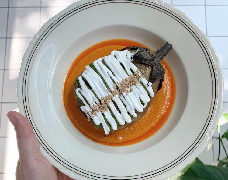 Melanzana arrosto, crema di pomodori e spezie, pesto alle erbe, labneh e sesamo