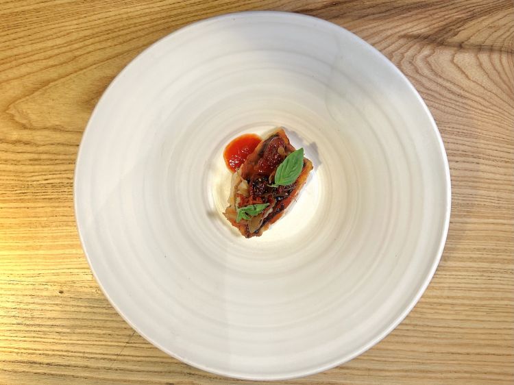 Merluzzo e sfincione: merluzzo cotto alla brace sulla pelle, laccato con estrazione ridotta di pomodorini, cipolla in agrodolce, pomodorini semi-dry maison, caviale di merluzzo, sardella, succo di datterino. «Siamo entrati in un territorio scivolosissimo, Baccalà e sfincione è un piatto della tradizione palermitana nella quale io mi sto ancora addentrando. Ho preferito usare il merluzzo perché ha nuances più delicate»