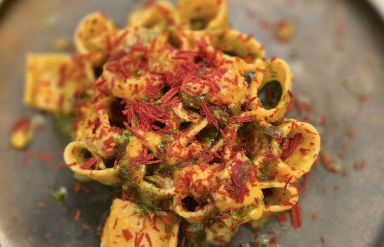 Mezzi paccheri con scorfano, datterino, giallo, basilico, fiocchi di pomodoro disidratato e granella di olive nere