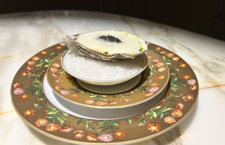 Champagne: Ostrica calda, salsa allo champagne e caviale. Assaggio pieno. L&rsquo;ostrica arriva dalla Normandia. &laquo;La cuociamo in una salsa allo champagne, questo apporta un&rsquo;acidit&agrave; molto distintiva. Sul fondo c&rsquo;&egrave; anche una vinaigrette di olio all&rsquo;aneto, acqua di ostrica e aceto di champagne. Infine aggiungiamo un po&rsquo; di caviale belga di GastroUnica, che scegliamo perch&eacute; &egrave; tra i migliori caviali ed &egrave; anche quello pi&ugrave; vicino alla Norvegia
