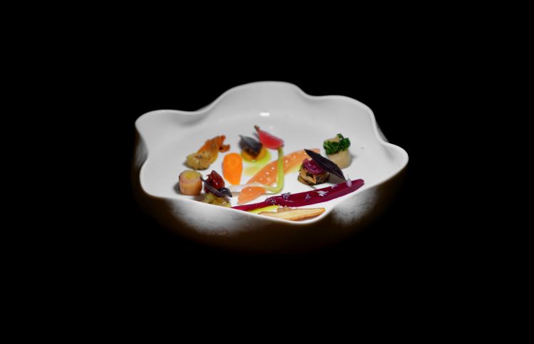 Qui è Ortolana dei nostri contadini, che cambia in base alla stagionalità. Nel nostro caso, gel di pomodoro sfumato con la grappa, cipollotto sbollentato, rapa sbollentata, carotina sbollentata, paté di olive, radice di cerfoglio piastrata, porro piastrato, creme di diverse rape, fiori di zucca in agrodolce, foglia di basilico viola, cardo sbollentato e ripieno di marmellata di cipolle rosse, ravanello sottaceto. Dritto, giusto, piacevole, non banale, «ho preso ispirazione da un piatto di Yannick Alléno. Mi è piaciuto così tanto che ho voluto in qualche modo replicarlo, stando sul territorio, le verdure sono 100% di contadini del posto», ci spiega Bernardi. Prima ancora, convincentissimi erano stati gli appetizer (Bon bon di manzo e maionese; Cialda di polenta con crema di sgombro, tartare di cetriolo e caviale; Tartelletta di grano saraceno con tartare di mela e acetosella e spuma di grano saraceno; Bao al finocchietto con maionese e cetriolo sottaceto, poi assaggi di speck e formaggio del maso Pretzhof) così come Il pomodoro di montagna, liquido, solido e ghiacciato, ossia pomodori locali in cinque versioni (ketchup, confit, caprese, granita, gazpacho)  con olio evo, cannella e basilico. E i pani: grissini di farina di segale e semola, pane ai cinque cereali, pane sfogliato con datteri, buchteln di patate, il tutto da accompagnare con hummus di melanzane con polvere di olive nere, burro delle Valli Orobie con fiori di erba cipollina e polveri di sambuco e pomodoro, infine olio evo Valentini. Tutte le foto seguenti sono di Tanio Liotta
