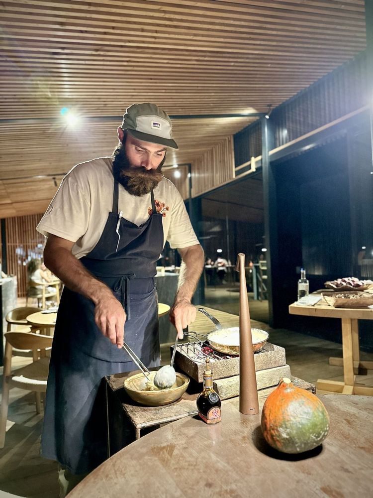 Chef Fabrizio Bartoli manteca al tavolo i Pici all'acqua di pomodoro, sfruttando una parte delle braci di olivo che vanno anche da affumicare la pasta