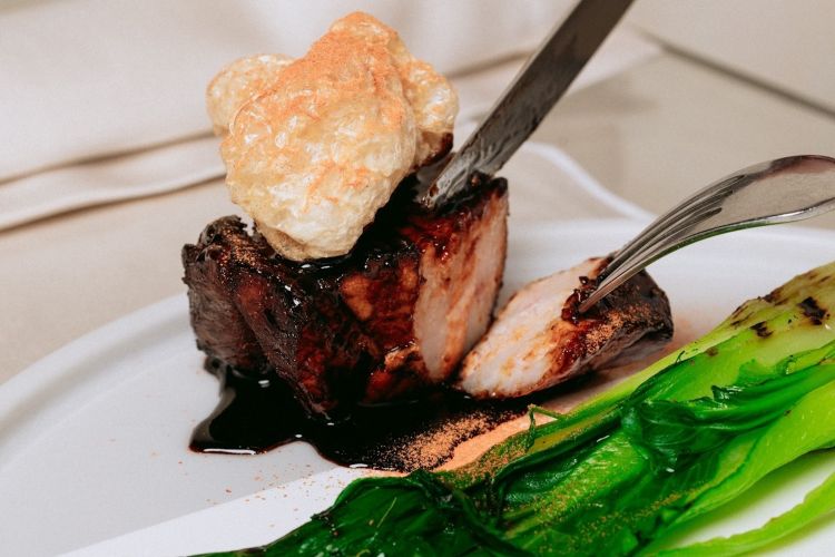 Pancia di maialino dei Nebrodi glassata alla soia, pak-choi in due cotture, la foglia ripiena di ricotta di capra