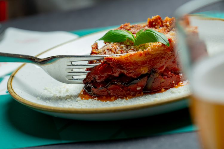 La Parmigiana di melanzane, un classico ben fatto con salsa di pomodoro al basilico fatta in casa e una frittura delicata che non lascia oleosa la bocca

