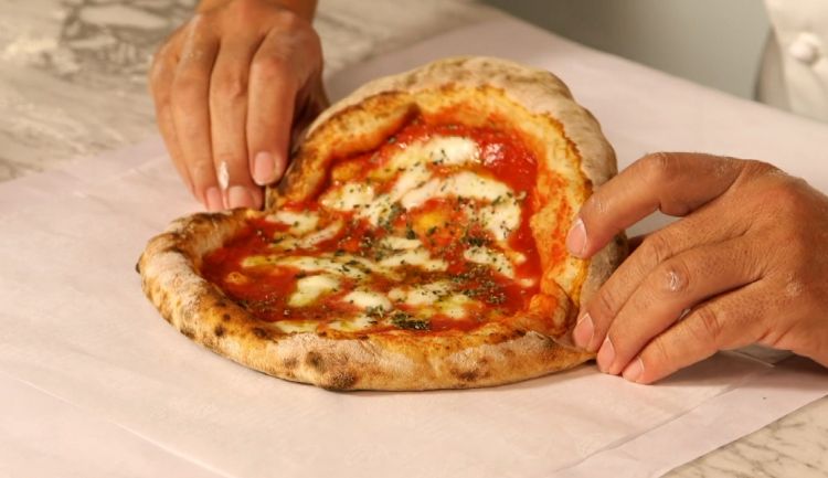 Mediterranea al cartoccio: the pizza is folded and wrapped in greaseproof paper, preserving its aromas differently from what happens with take-away cartons, and making it more sustainable
