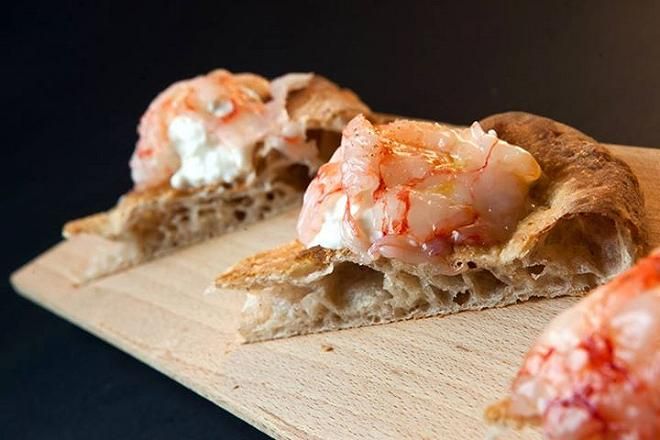 Una pizza mitica di Simone Padoan: focaccia romana al mais e semi di girasole, con ceviche di gamberi rossi, finocchio all’arancia e burrata