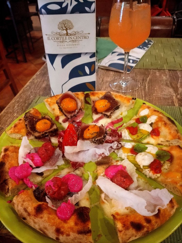 Le pizze di Signoretti giocano molto anche con i colori e trovano facile abbinamento con una carta cocktail ad hoc. Qui, in sottofondo, Paloma a base di tequila, succo di lime, pompelmo rosa bio