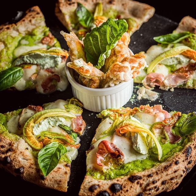 La pizza alle zucchine omaggia gli ospiti di un fritto di fiori di zucca farciti con ricotta
