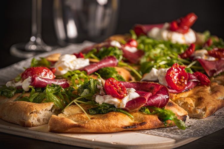 La pizza in pala Angus di OMG! La pizza di Gennaro Melillo: Black Angus, pomodorini semidry, stracciata di bufala, rucola, parmigiano, pepe nero, zest di limone e olio EVO