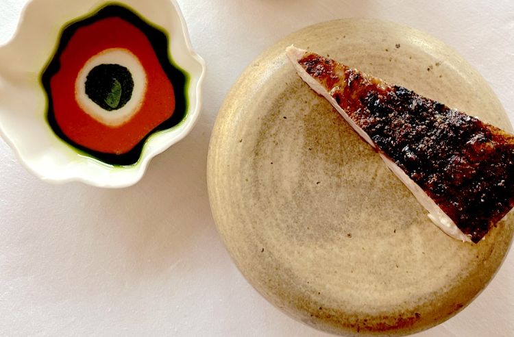 La finta pizza, in realtà è pancia di ricciola, cotta sulla brace soltanto dalla parte della pelle