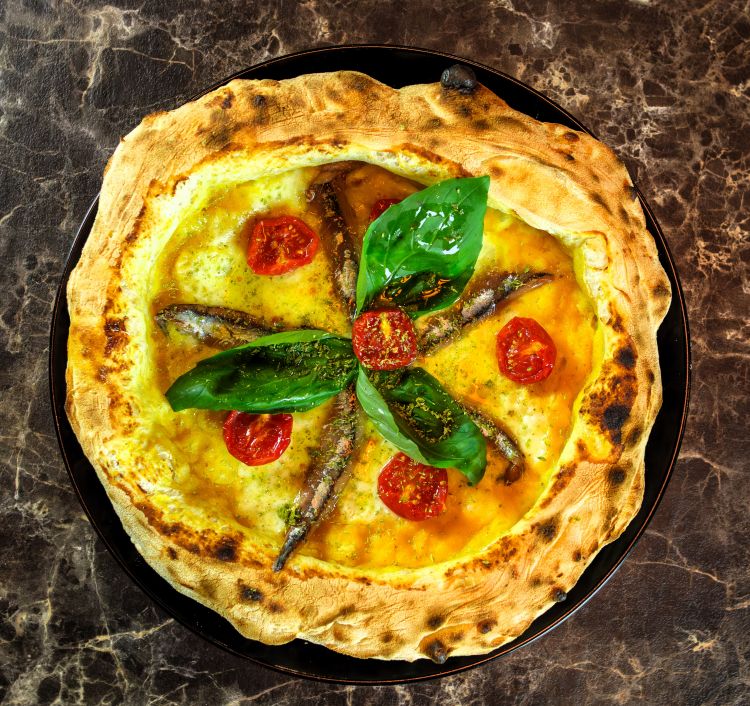 Altro fiore all'occhiello de I bravi ragazzi è la Siciliana con pomodoro datterino giallo, fiordilatte Latteria Gargiulo, pomodorini confit, acciughe sottosale del Cantabrico, origano, basilico fresco, olio infuso al limone