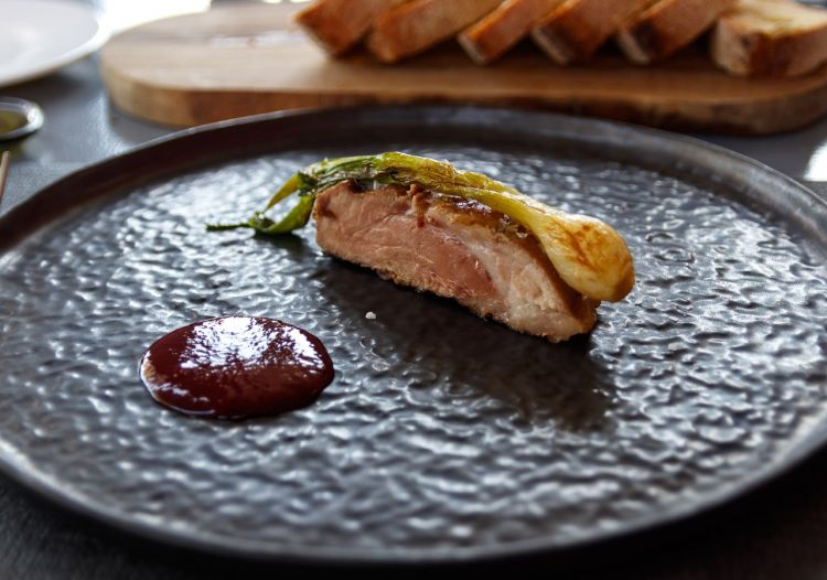 Pluma di maialino iberico cotta a bassa temperatura e servita con cipollotto alla brace e ketchup di lamponi