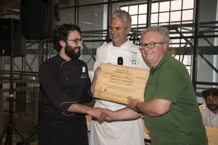 Lo chef Matteo Carelli (Svizzera), ha servito Lo gnocco in piatti neri su un letto di salsa verde accentuando così l’effetto visivo. Dal Canton Ticino ha portato la “farina bona”, l’olio del Ceresio e un aceto balsamico stavecchio ticinese. Ha insomma ricordato che nella Svizzera italiana non mancano prodotti di eccellenza. Con Mangia la foglia Carelli ha voluto abbracciare il Festival e alle foglie ha aggiunto un riuscito “formaggino” a base di mandorle. A quest'ultimo, Luca Morari di Ricola, partner dell'evento, ha consegnato il premio speciale Le 13 Erbe Ricola (nella foto), motivandolo così: «Per la sua sensibilità nel cogliere sapori e profumi trasformandoli in cibi buoni e naturali attraverso le sue creazioni culinarie presentate in concorso»