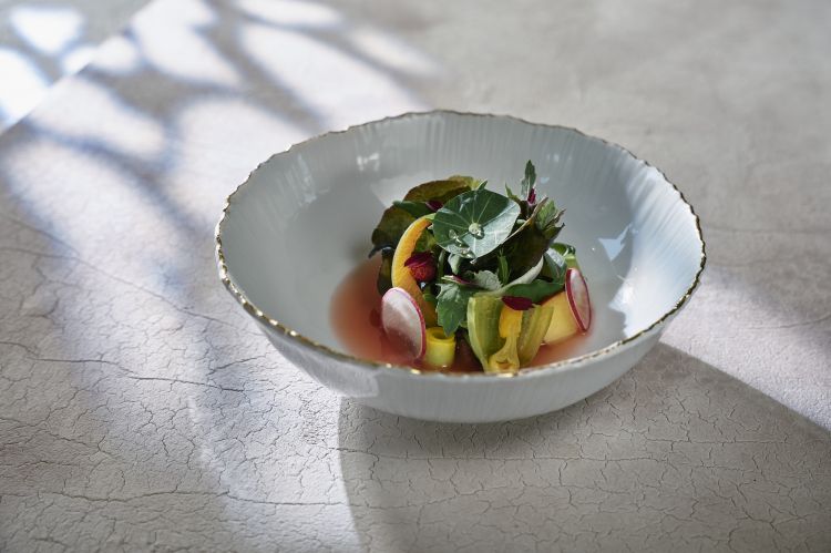 Raccolto primaverile - Un capolavoro. &laquo;Questo piatto resta in menu per tutta la stagione: lo cambiamo man mano che cambia la natura. Sul fondo troverete un succo a base di asparagi e piselli verdi. Sopra lavoriamo soprattutto con frutta e verdura fresche di stagione: per esempio qui avrete fragole fresche, poi piccoli pezzi di mela e pera con un po&rsquo; di mela cotogna. A lato avete anche spugnole: le prime, le abbiamo prese oggi. In cima ecco diverse variazioni di insalate, erbe, piante spontanee e verdure che raccogliamo noi o che ci arrivano dalla nostra forager, Mija. L&rsquo;idea &egrave; mescolare tutto insieme: in pratica &ldquo;condite&rdquo; la vostra insalata da soli,&nbsp;sul fondo trovate anche un gel a base di zucca&raquo;
