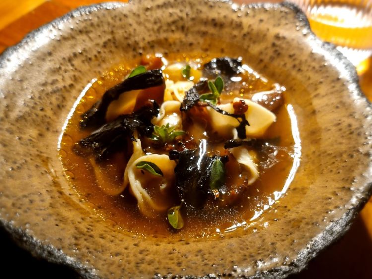 Raviolino di Palamita affumicata in dashi di funghi shiitake e trombette da morto, salsa matcha e maggiorana