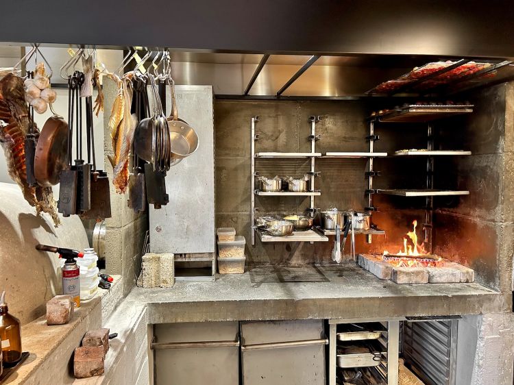 The open kitchen, featuring fire and embers