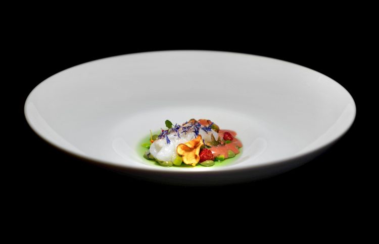 Scampo, asparagi e clorella: lo scampo è affumicato, al tavolo, a freddo, con olio alla menta. Alla base, asparagi di diversi colori e consistenze (bianchi e verdi), fragoline di bosco, emulsione di fragoline di bosco, clorella (un’alga di fiume) e topinambur. Come side, il crudo della chela dello scampo con maionese alla menta. Oggi è Scampo, clorella, fragoline di bosco