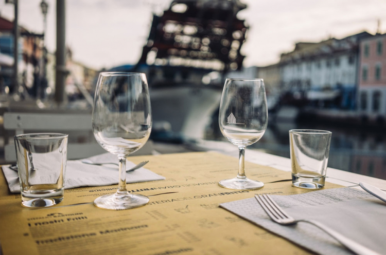 Un tavolo all'Osteria del Gran Fritto di Cesenatico e, sotto, lo stesso gran fritto che vi viene servito