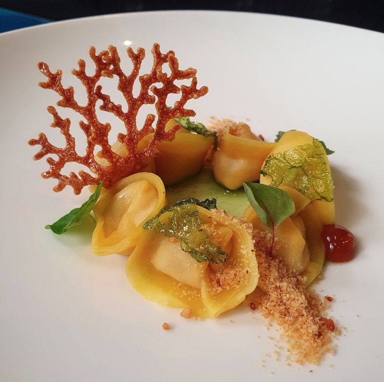 In fondo al mar: ravioli ripieni di zuppa di pesce, crumble di tarallo e bottarga, alghe di mare e corallo
