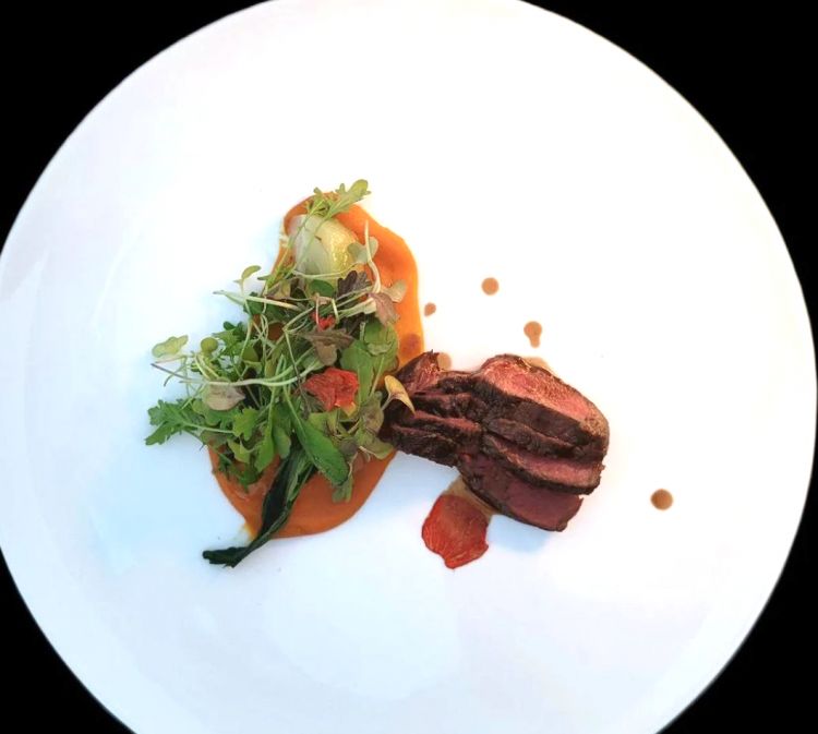 Manzo Marango alla fiamma, patata dolce ed erbe amare
Nell’ultimo piatto ritroviamo la carne di manzo Marango (un incrocio tra la Maremmana e la Frisona con il  Black Angus). In questo caso ci viene proposto il filetto scottato alla fiamma, cottura al sangue, e viene accompagnato da una crema di patata dolce ed erbe amare
