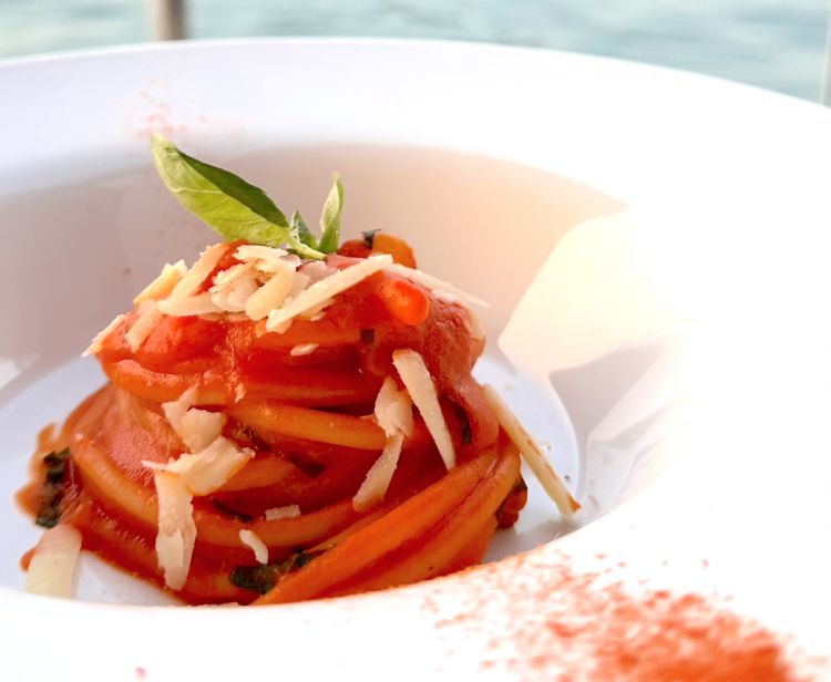 Spaghettone Benedetto Cavalieri 1918, pomodoro di Capobianco, basilico e parmigiano reggiano Val Serena
Un piatto all’apparenza molto semplice, ma che in realtà nasconde tante insidie in quanto fare una buona pasta al pomodoro non è così facile. In questo caso lo spaghettone viene mantecato con il pomodoro pugliese di Capobianco al quale lo chef aggiunge foglie di basilico e parmigiano Reggiano Val Serena
