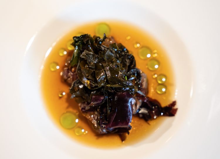 Pecora, alghe e pino
Pecora in tataki, dal cuore crudo, appena scottata all'esterno, tenace e delicata, assorbe il calore leggero del brodo che apporta sapidità e rotondità alle carni; ancora sapidità, a nostro avviso un po’ troppo spinta nell’insalata di alghe, wakame, lattuga di mare, alga dulce che sbilanciano l’assaggio e privano di forza la carne