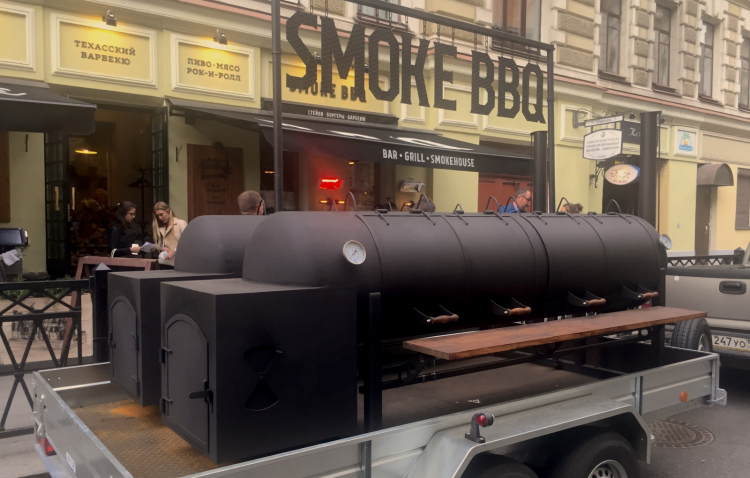 A mega-barbecue on wheels, in front of restaurant Smoke Bbq, in Ulitsa Rubinshteyna, a popular street at night
