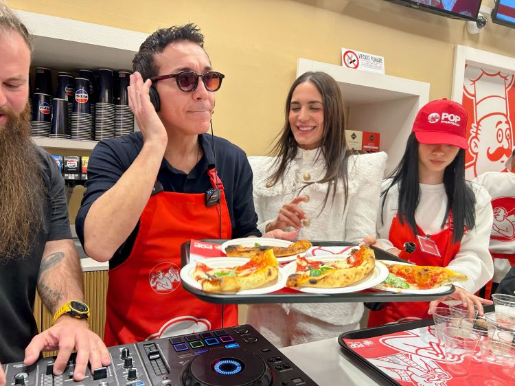 Un momento dell'inaugurazione di Pop, in via Cappellari 3 a Milano, con Gino Sorbillo in versione dj mentre distribuisce la sua pizza Margherita a ritmo di musica