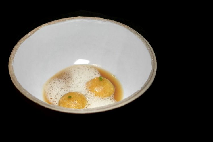 Speck und brot: ravioli di pane avanzato (nell&rsquo;impasto) con ripieno di pane, schiuma di aceto di pane vecchio, brodo di pane e speck e pancetta fatta in casa. In accompagnamento, una kvas&nbsp;di pane fermentato affinata con frutta (ciliegia, mela eccetera)
