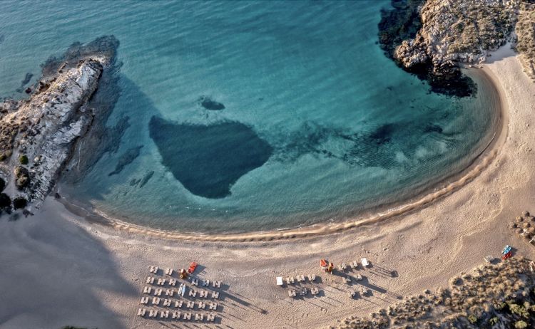 La mezzaluna della spiaggia privata del Resort (in parte anche pubblica), sulla scenografica insenatura di Su Portu