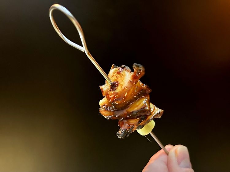 Spiedino di polpo alla brace laccato con salsa teriyaki di melassa di carruba, insalatina di puntarelle, mandorle verdi in salamoia, finocchietto selvatico e cerfoglio
