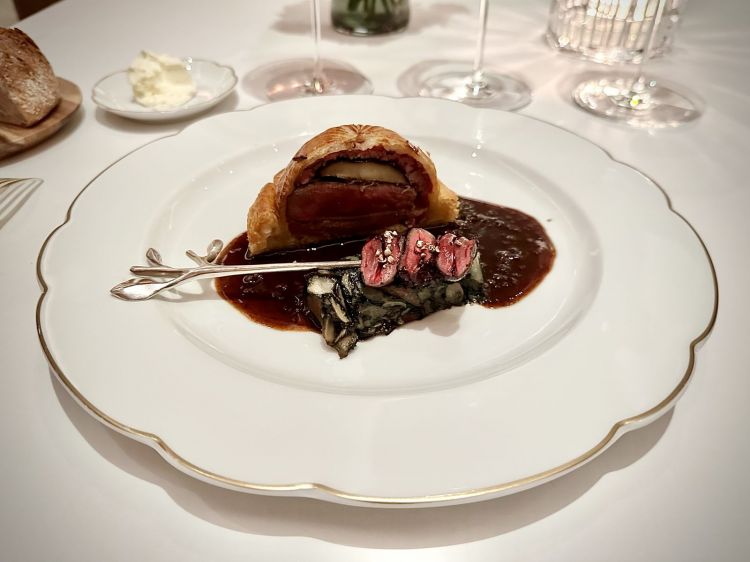 Pithivier di piccione, spiedino di cuori di piccione, il suo fondo, melanzana: in un grande classico come questo, dov'è il tocco contemporaneo? Per esempio, nel rivestimento della melanzana, fatto con un delicatissimo carpaccio di piedini di vitello, tanto da sembrare un altro vegetale. L'insieme è incredibilmente leggero, grazie alla cottura perfetta del piccione, alla sfoglia millimetrica e al fondo preparato fresco e tirato come si deve. Classico non sempre vuol dire opulento... 
