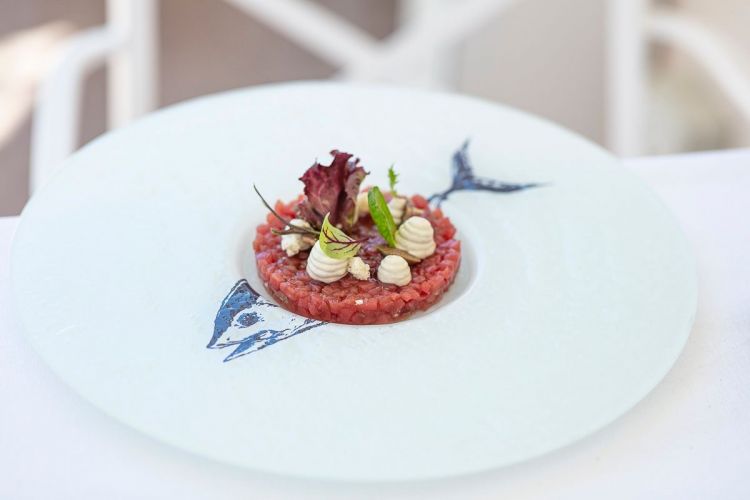 Tartare di tonno rosso del Mediterraneo: è un po' il simbolo del gusto puro di mare che vuol fare assaggiare Joseph Micieli, cosa perfettamente eseguita con questo antipasto. Usa tre parti del tonno (filetto, ventresca, tarantello) e le condisce leggermente con maionese ai capperi, acciuga di Lampedusa (in omaggio all'edificio che ospita Scjabica, che era una sardara, dove veniva lavorato il pesce azzurro per le conserve), crostini. La ceramica che contiene la tartare è stata creata appositamente (foto Rossana Brancato)
