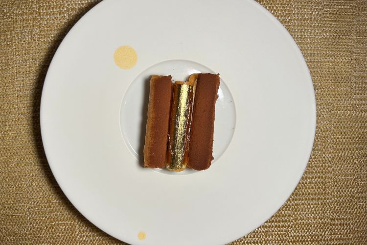 Tiramisù - Strepitoso, meglio di qualsiasi versione originale, perché dona croccantezza e profondità. È ovviamente diventato uno dei piatti signature di Vania Ghedini e anche uno dei primi elaborati quando le è stato chiesto di assumere la guida di Oro. La riflessione parte da un limite che lo chef individua nel tiramisù classico: una consistenza sempre molto morbida. Da qui nasce una versione più strutturata, anche nella forma. La geometria del dessert richiama infatti l’architettura originaria del ristorante: la parte centrale ricorda la grande cupola ovale dorata dalla quale Oro prende il nome, mentre le tre cupolette rappresentano le tre vetrate affacciate sulla laguna veneziana