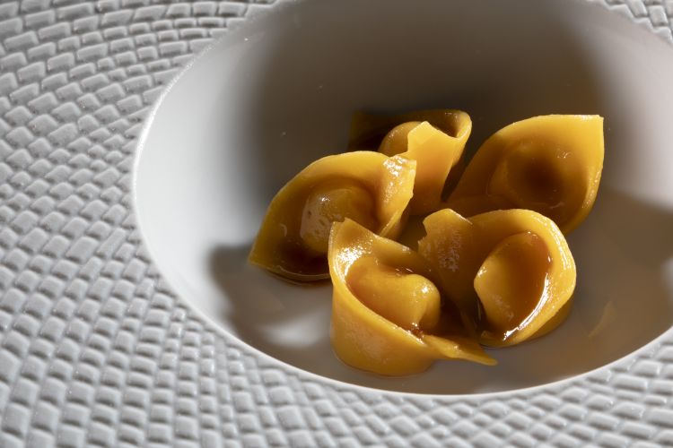 Tortello di parmigiano 50 mesi, panna e noce moscata, mantecato in acqua di parmigiano con cipolla e salsa barbecue texana vegetariana