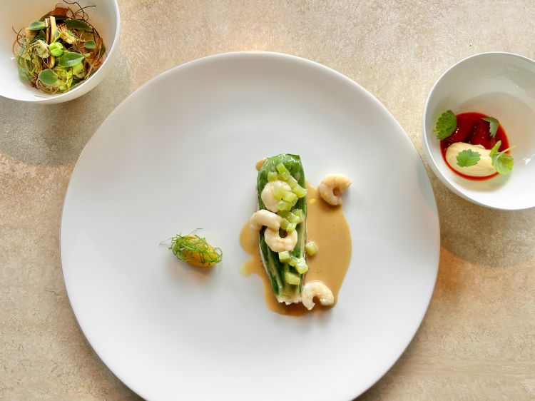 Triglia in crosta, pak choi, salsa di arachidi e gamberi gobbetti. Il pesce è accompagnato da foglie di pak choi, una salsa a base di arachidi e lemongrass, i gamberi gobetti, i gambi di sedano e una salsa di lulo, un vegetale sudamericano della famiglia dei pomodori, dal sapore fresco e acido, con acetosa. Come side: una rivisitazione della vignarola e un piattino con peperone, vaniglia e foie gras