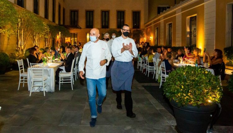 In primo piano, Andrea Ribaldone e Antonio Guida ricevono l'applauso del pubblico a fine cena, seguiti dalle brigate di sala e cucina
