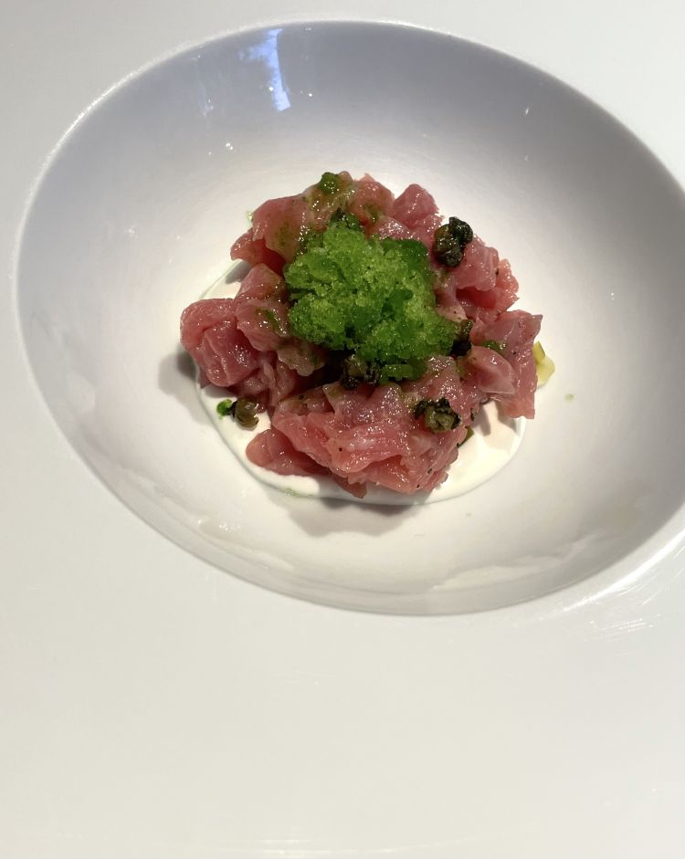 Granita di prezzemolo, capperi e battuta di filetto. Si parte dal filetto, una battuta tagliata al coltello per dare valore innanzitutto alla masticabilità, a tutti gli effetti componente del gusto. Viene condita con capperi, e coronata da una granita al prezzemolo che definisce ulteriormente la temperatura di servizio (ambiente/fredda), mentre alla base un velo di burrata amalgama il tutto. Freschezza estrema, carne delicata e vegetale ben definito grazie alla nota aromatica del prezzemolo