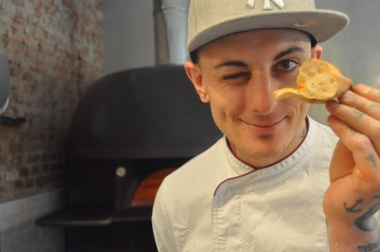 Matteo Mevio mostra orgogliosamente il "cornicione" della sua pizza

