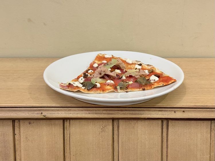 Uno sguardo alle Eolie, con topping studiato insieme allo chef Nino Ferreri: impasto di farine tipo 1 e segale, salsa di pomodoro pelato siccagno, ventresca di tonno, capperi di Salina, sedano croccante, terra di olive, cipolla caramellata, bottoni di vellutata di acciughe, zeste di limone