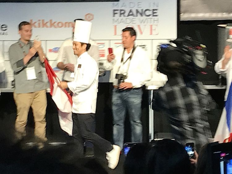 The smiling winner: Yusuke Aoki walks quickly to the centre of the stage to get trophy and cheque