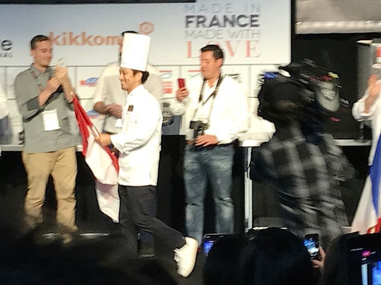 The smiling winner: Yusuke Aoki walks quickly to the centre of the stage to get trophy and cheque 
