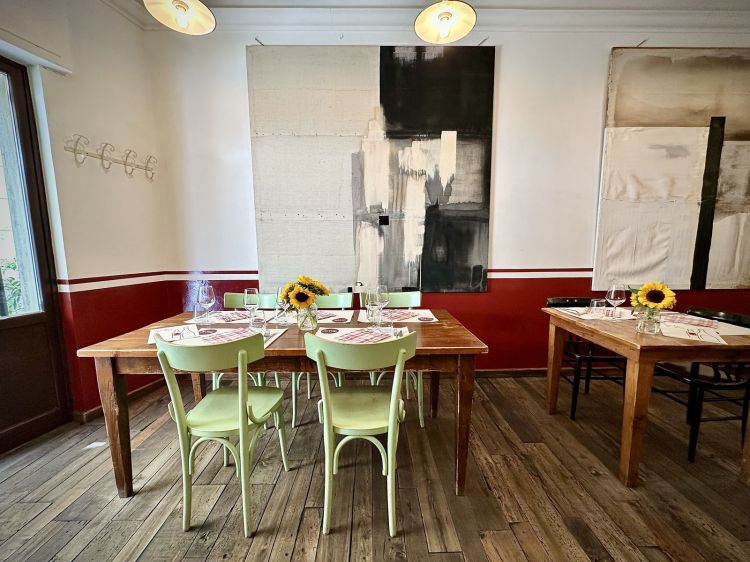 L'interno della piccola sala: sedie e tavoli in legno, atmosfera da trattoria, impreziosita dalle opere di Andrea Franceschini (Billy), un caro amico artista di Riccardo, purtroppo prematuramente scomparso
